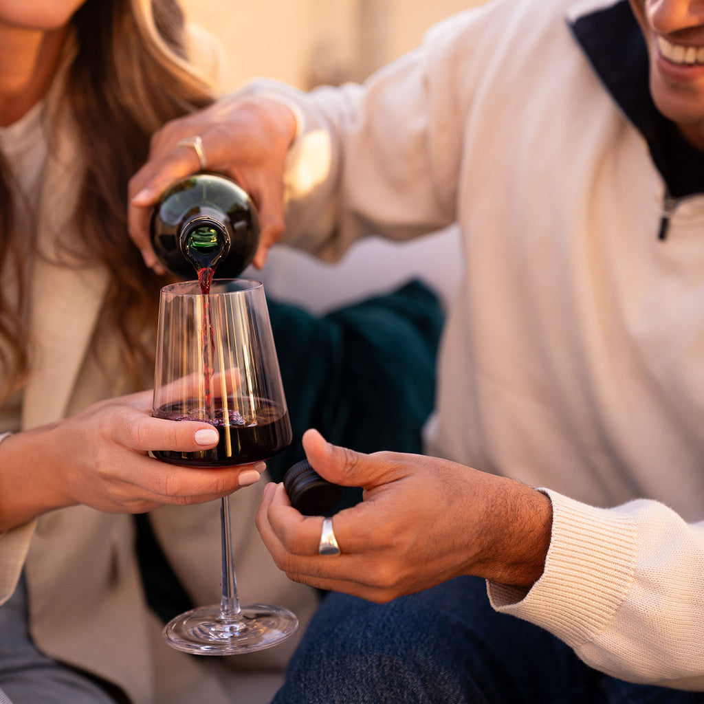 Süss & Fruchtig Rotwein der WZG wird aus der Flasche in ein Weinglas eingeschenkt.