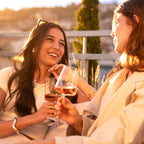 Zwei Frauen genießen gemeinsam ein Glas Süss & Fruchtig Roséwein der WZG in sonniger Atmosphäre.