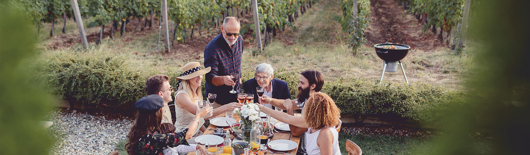 Menschen essen gemeinsam am Tisch in den Weinbergen und trinken Wein WZG Weinserie Spezialitäten aus dem Ländle